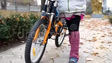 一个高加索儿童在秋季公园骑自行车。